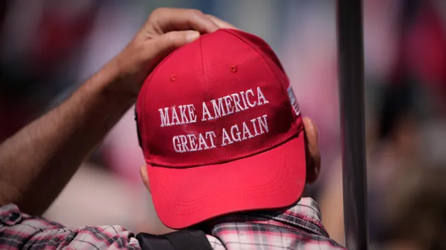 A man in a backwards red MAGA hat